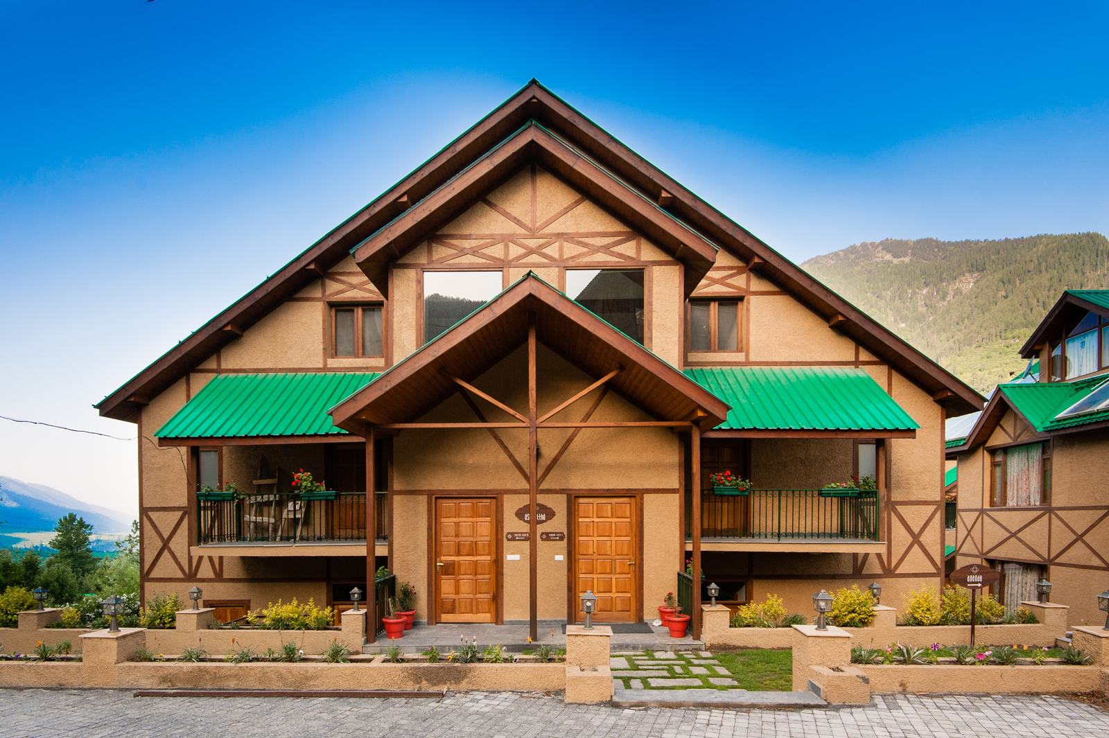 Front of a Tudor-style villa with green awnings